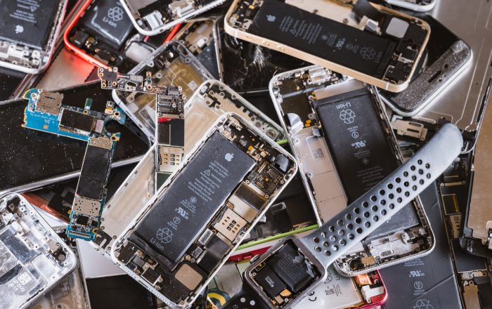 A pile of mobile phones and smart watches with their back covers removed